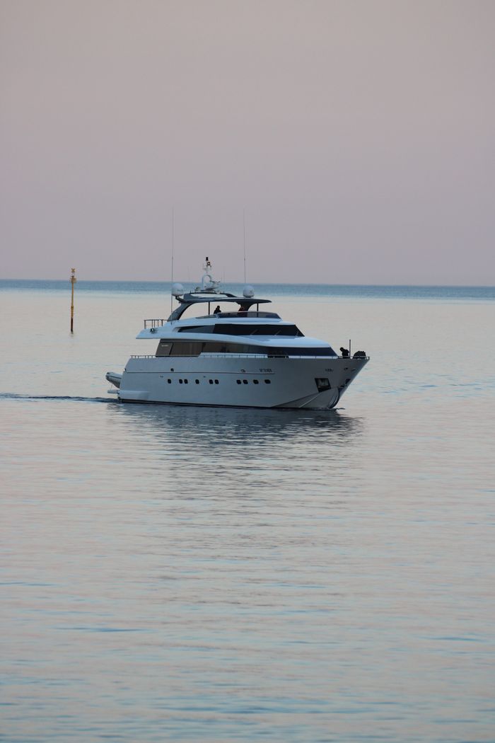 gallery-3 Elegant yacht cruises on serene waters near Portofino, Italy, during a tranquil sunset.