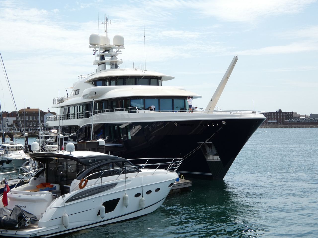 about-img A luxurious yacht docked at Portsmouth Marina under a clear blue sky.