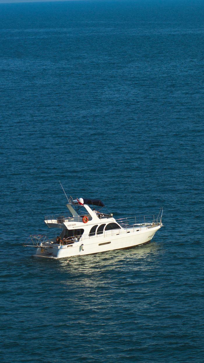 hero-img-01 A stunning white yacht sails on the tranquil blue sea near Antalya, Türkiye, epitomizing luxury and travel.